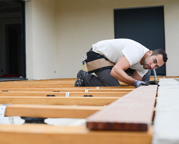 Expert deck builder lining up premium lumber material for custom deck project.